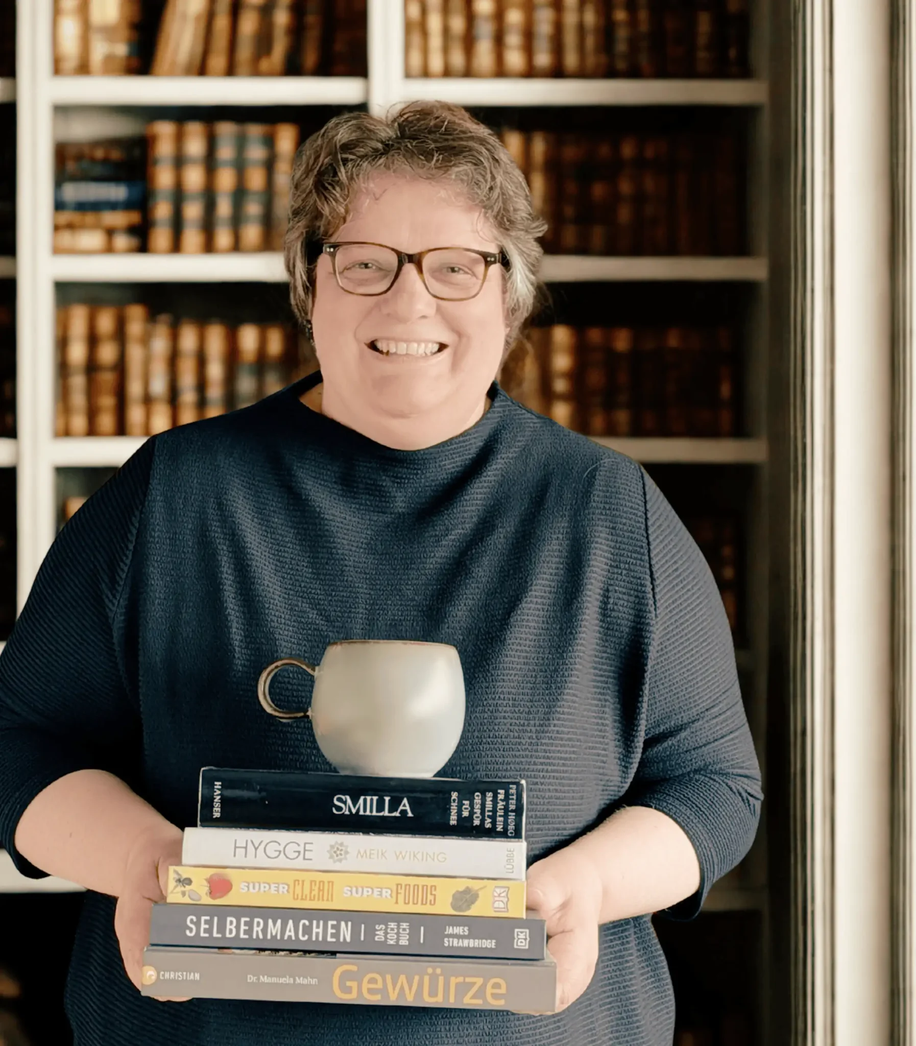 Dani von der Buchhandlung Lykke mit einem Stapel Bücher