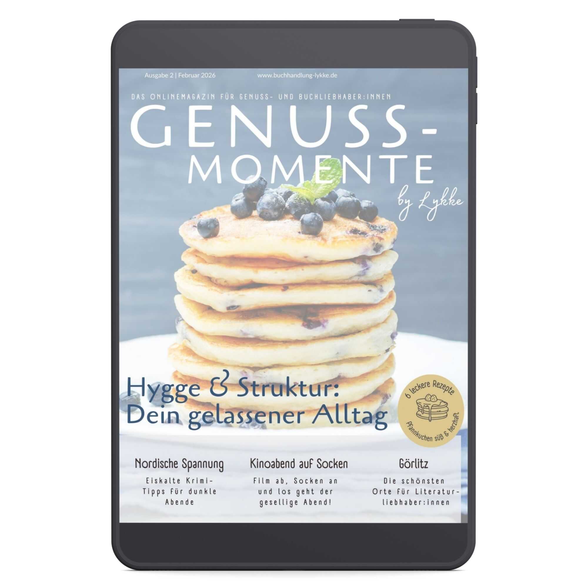 Magazin-Cover von „Genuss-Momente by Lykke“ (Ausgabe Februar 2026) auf einem Tablet. Es zeigt einen Stapel Blaubeer-Pfannkuchen und die Überschrift „Hygge & Struktur: Dein gelassener Alltag“.